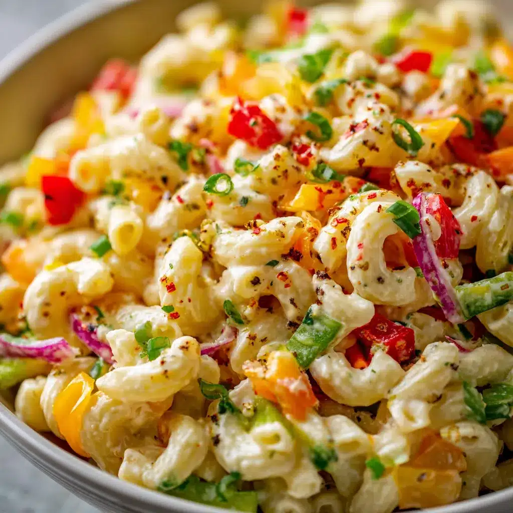 Bowl of classic creamy macaroni salad with diced vegetables and fresh parsley.