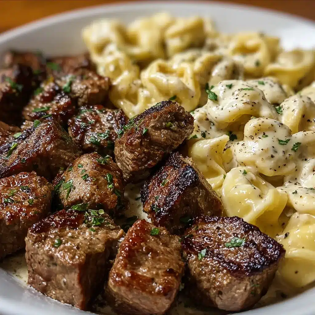 Creamy garlic butter steak bites served with tortellini in Alfredo sauce in a white skillet.