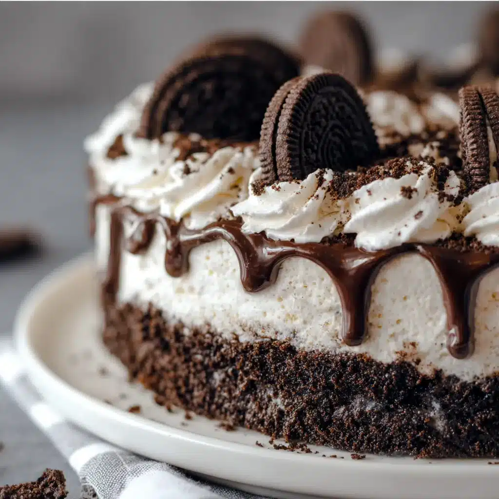 Slice of creamy No-Bake Oreo Cake topped with mini Oreos on a white plate.