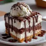 No-bake hot fudge ice cream cake slice with Oreo crust and whipped cream topping