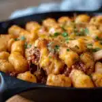 Tater Tot Sloppy Joe Skillet with melted cheddar and crispy tater tots in an oven-safe skillet