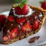 Slice of Chocolate Covered Strawberry Pie with fresh berries and chocolate ganache on a plate.