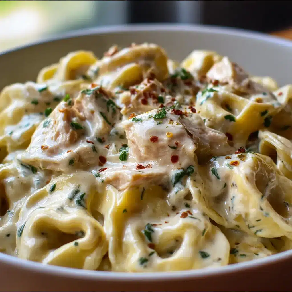 A creamy bowl of Crockpot Chicken Alfredo Tortellini garnished with fresh parsley and Parmesan.