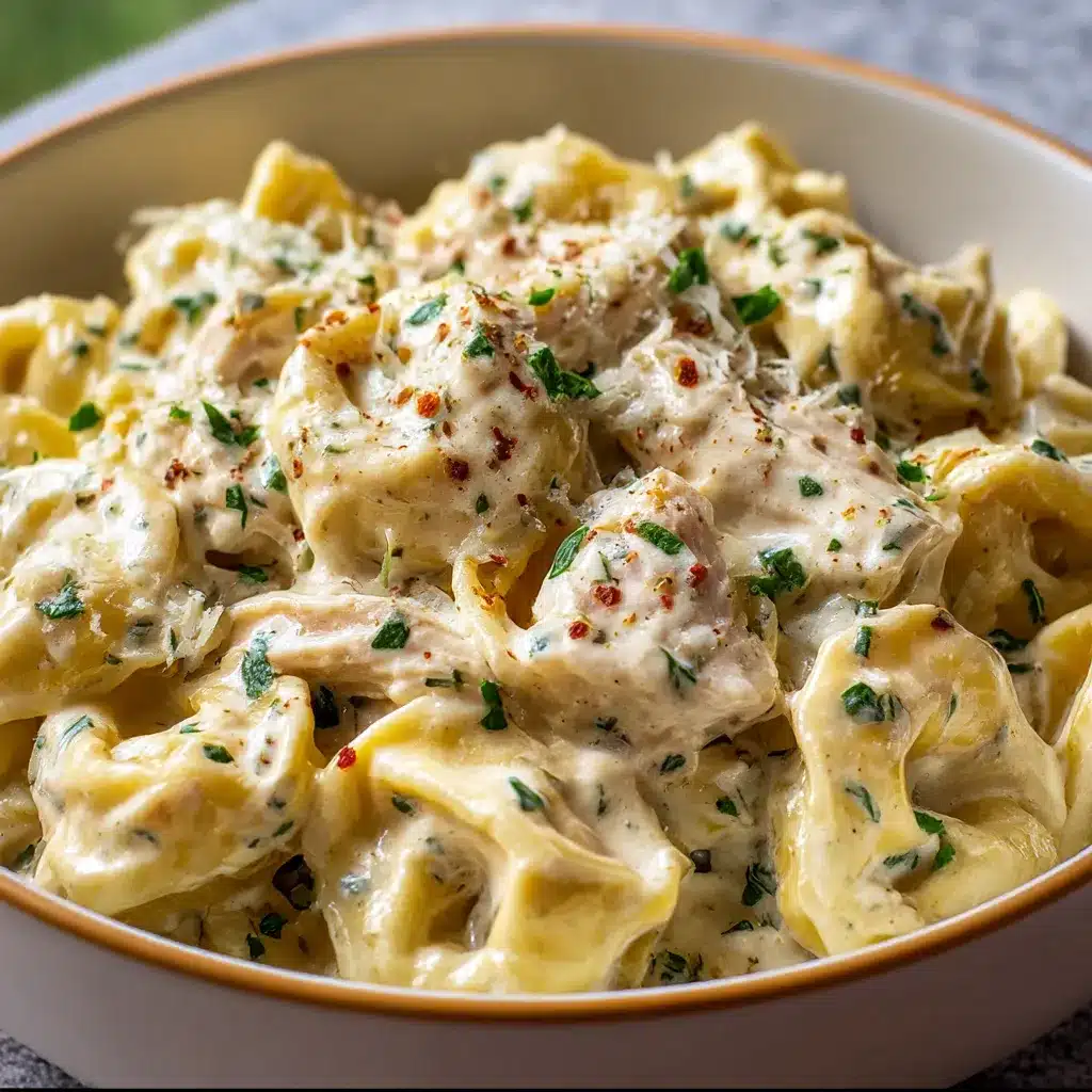 A creamy bowl of Crockpot Chicken Alfredo Tortellini garnished with fresh parsley and Parmesan.