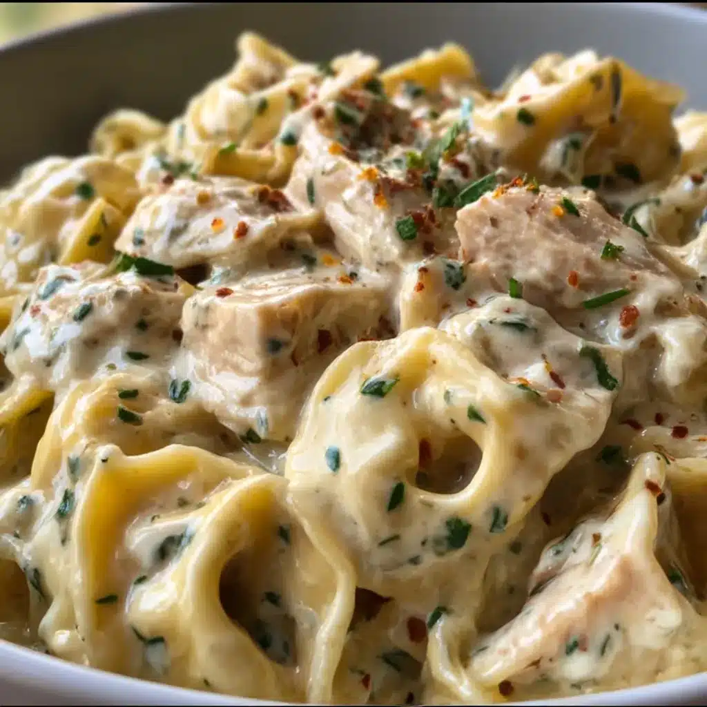 A creamy bowl of Crockpot Chicken Alfredo Tortellini garnished with fresh parsley and Parmesan.