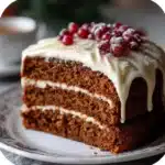Slice of homemade gingerbread cake with cream cheese frosting on plate