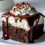 Baileys Chocolate Poke Cake topped with chocolate ganache and whipped cream