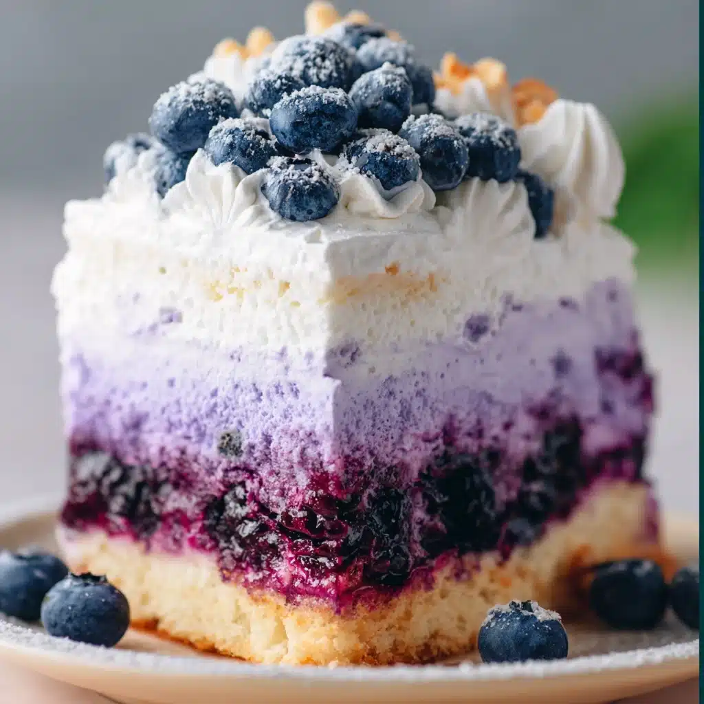 Slice of Blueberry Cloud Cake with whipped cream frosting and fresh blueberries